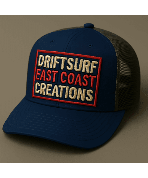 A blue and gray trucker hat with a colorful patch saying 'Driftsurf East Coast Creations'.