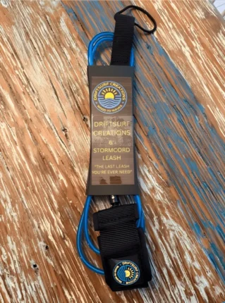 Blue surf leash on wooden surface.
